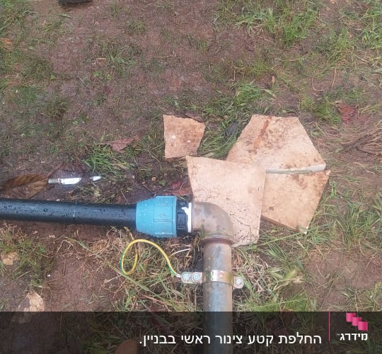 צינור פלסטיק עם מחבר מתכת על אדמה רטובה
